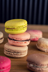 stack of macaron cookies on wooden table and dark background