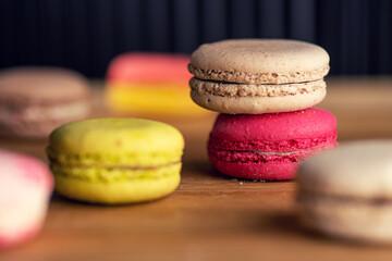 stack of macaron cookies on wooden table and dark background