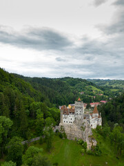 Medieval Bran Castle, aerial drone perspective. Known as Dracula's Castle, it is visited annually by many foreign tourists. One of the best-known tourist attractions of Romania. Vertical photography.