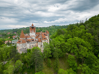 Fototapeta na wymiar Medieval Bran Castle, aerial drone perspective. Known as Dracula's Castle, it is visited annually by many foreign tourists. One of the best-known tourist attractions of Romania