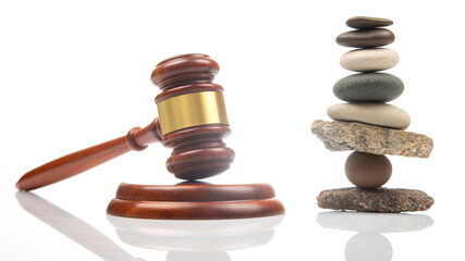 pyramid of stacked stones and a gavel of justice and law on a white background. stabilization and...
