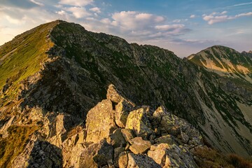 Summer hiking in the mountains with massive rocks, dramatic skies and majestic mountains. Mountain sunset in Slovakia mountain - Rohace, Mountain hiking holiday Western Tatras.