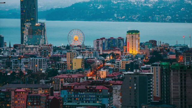 Batumi, Adjara, Georgia. Elevated view Ferris Wheel At Promenade In Miracle Park, Amusement City Park during Evening. Evening change to Night Time. timelapse day to night