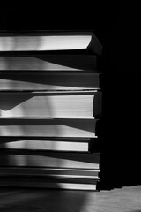 stack of books with abstract shadows in black and white mode