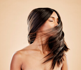 Woman, beauty and shake hair in studio for aesthetic shine, volume and smooth shampoo results. Indian female model, salon treatment and wind in hairstyle for growth, soft texture and cosmetic care