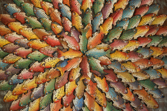 Um c&iacute;rculo encantador preenchido por peixes de madeira coloridos, uma obra de arte artesanal que traz vida e alegria ao ambiente.