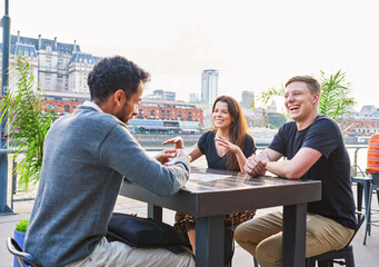 latin american young adult friends  sitting outdoors chatting  and having fun