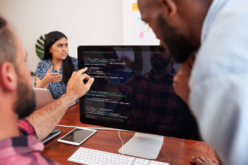 Two developers peer programming together in office, assisting peer review