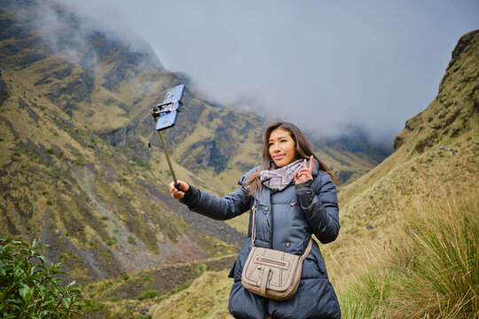 latina woman taking selfi in the cold heights in the mountains of la paz bolivia