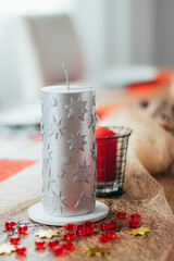 Dinner table decorated with candles and pine cones to celebrate Christmas Eve.
