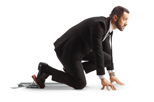 Full length profile shot of a businessman preparing for a run on starting blocks