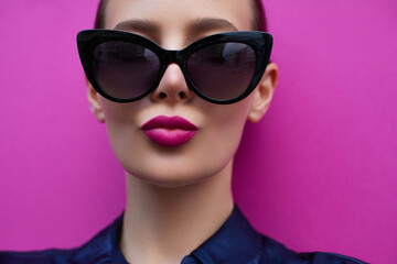 Sunglasses fashion model portrait.  Classic style glasses shape.  Pink lips blowing kiss. Beautiful...