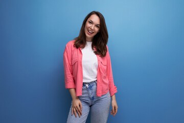 well-groomed european brunette 30s woman in pink shirt on studio background