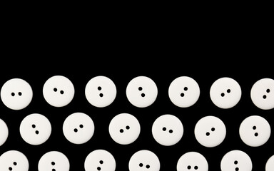 Black background with white plastic round buttons