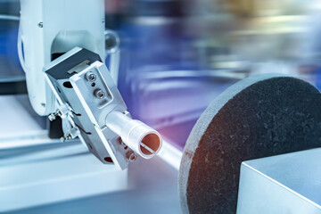 automatic arm handling the metal machined shaft parts polishing between the production line. automotive parts manufacturing process.