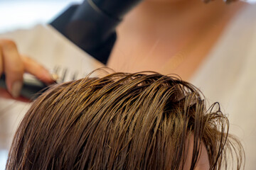 drying hair with a hair dryer at the barbershop