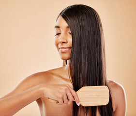 Face, hair beauty and brush with a woman in studio on a cream background for natural or luxury style. Haircare, growth and shampoo treatment with a young indian female model eyes closed at a salon