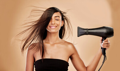 Hair, dryer and smile of woman in studio for beauty, grooming and heat equipment on background....