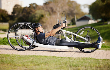 Cycling, fitness and cardio with man and handcycle in nature for training, sports and challenge. Exercise, workout and marathon with person with a disability in park for wellness and health on road