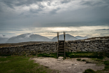 Ladder style over a dry stone wall on the walk path in Mourne mountains. Ireland.