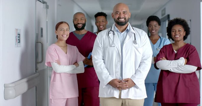 Happy diverse doctor smiling in hospital corridor, slow motion