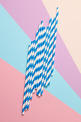 Blue paper straws on pastel background. Party, birthday accessories