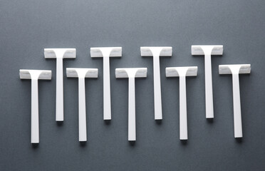 Disposable white plastic razors on a dark gray background