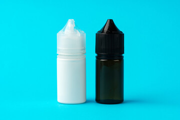 Electronic cigarettes liquid bottles on blue background