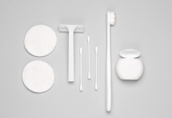 Hygiene products. Razor, dental floss, toothbrush, cotton buds and pads on a gray background. Flat...