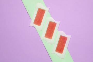 Wax strips for depilation on pastel background. Beauty concept. Top view