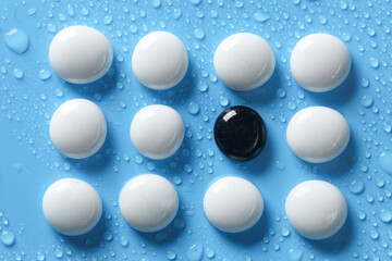 White and black pebbles on a blue background with water drops. spa, relaxation therapy