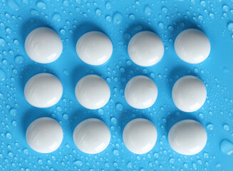 White pebbles on a blue background with water drops. spa, relaxation therapy