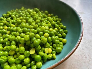 young green peas, plate with hot cooked peas, garden harvest, summer vegetables