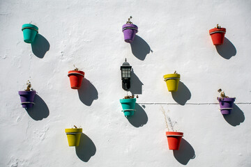 Colored pots without flowers on a whitewashed wall typical of the white villages of Andalusia © AntonioLopez