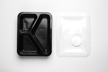 Disposable black plastic empty food container on gray background. Top view