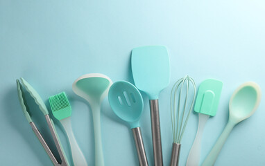 Silicone kitchen utensils on blue background. Top view