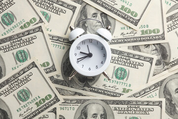 Alarm clock on hundred dollar bills. Time is money