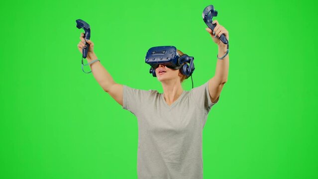The girl wearing VR headset flying in virtual reality in video game. The woman in virtual reality on chroma key green screen turn around in flying. Concept fly sport game VR headset virtual reality