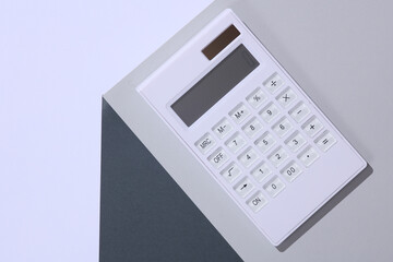 Calculator on the corner of gray cube. Optical geometric illusion. Business concept. Creative layout. Minimalism