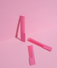 Plastic combs on pink pastel background. Beauty concept. Creative layout, minimalism