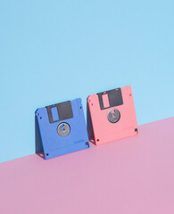 Pink and blue Floppy disks on pastel background. Retro 80s. Outdated technology. Creative layout,...