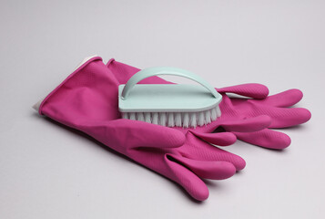 Accessories for cleaning. Gloves and brush on gray background.