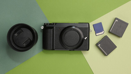 Photographer's equipment. Modern digital mirrorless camera with lens, batteries and sd memory card...