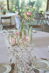 Floristics. Floral decoration of the wedding in pastel colors. Many flowers in different vases and vessels