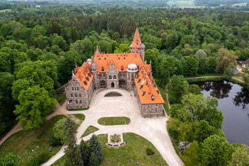 Cesvaine medieval castle in Latvia from above. Building of stones with a brown tiled roof. - obrazy, fototapety, plakaty