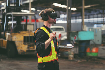 Male factory mechanic using virtual reality headset. Male engineer working or using virtual reality headset for checking machinery in industry factory and wearing safety uniform and helmet