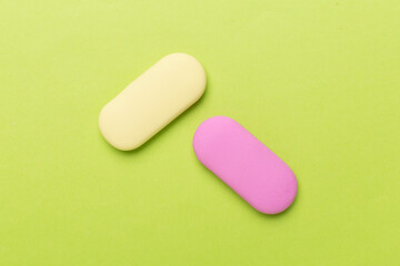 Colorful eraser on color backgroung, top view