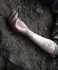 Hand of a wounded soldier on the ground