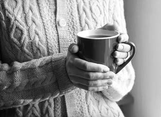 Women's hands holding a warm cup