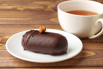 Delicious chocolate cake in white plate on wooden table background
